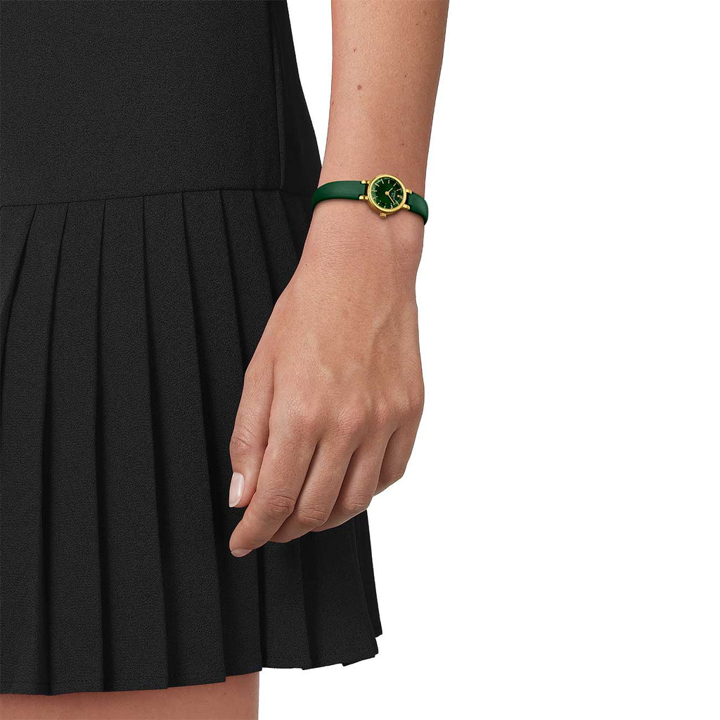 View of tissot gold and green watch on models wrist